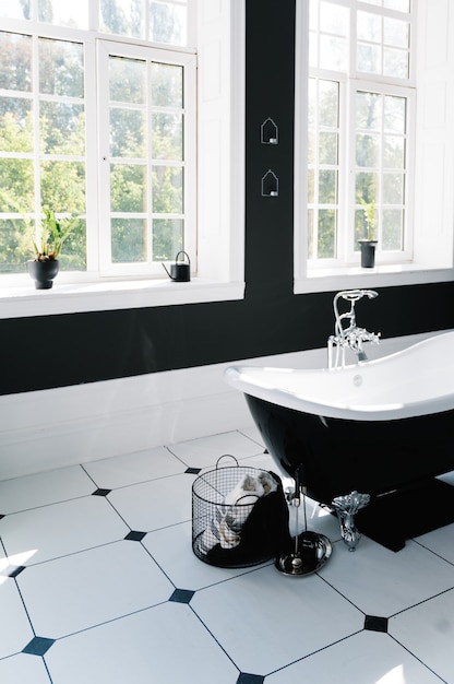 Interior de baño con ventanas y bañera con patas.