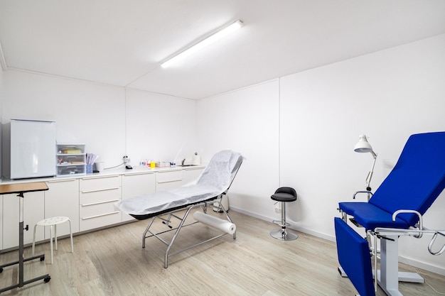 Interior branco do novo escritório de clínica moderna com cadeiras azuis para procedimentos de beleza