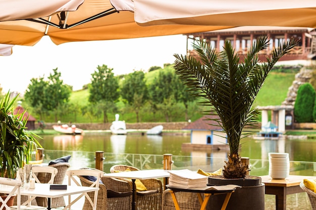 Interior de cafetería de verano al aire libre con fondo de lago borroso