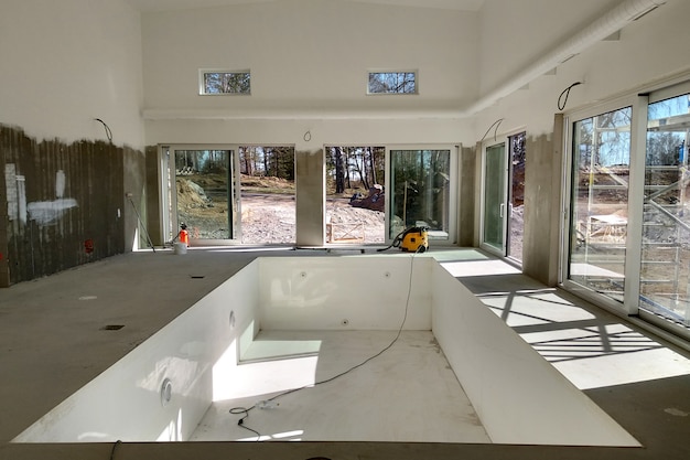 Interior de una casa con gran piscina en obras de renovación.