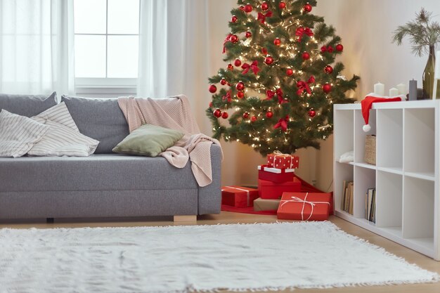 Interior de la casa de Navidad elegante salón con sofá de árbol de Navidad y cajas de regalo con regalos