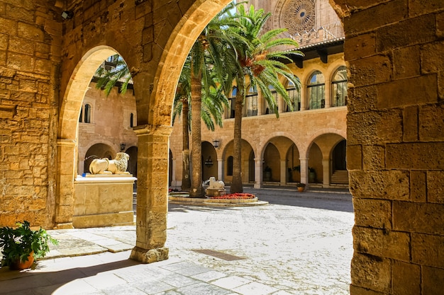 Interior de la catedral de Mallorca con patio y arcos de piedra.