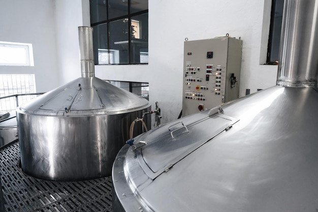 Interior de la cervecería de fábrica moderna con tanques en el interior