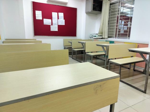 Foto interior de una clase escolar vacía con un tablero rojo