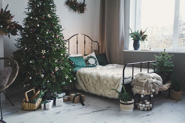 Interior clássico de Natal com uma árvore decorada. Cama vintage e árvore com presentes