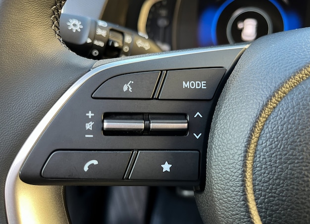 Interior del coche con botones de control de crucero, comunicación por voz en el volante.