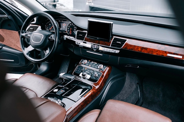 Foto interior de coche de primera calidad, cuero marrón perforado, inserciones decorativas en el interior, volante de cuero.
