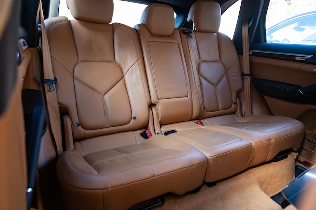 El interior del coche con vistas a los asientos traseros y las puertas con tapicería de cuero marrón claro