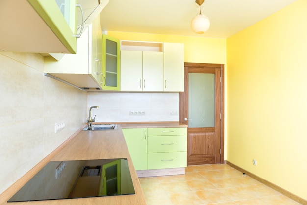 Interior de cocina en apartamento moderno. Habitación soleada vacía de color amarillo claro