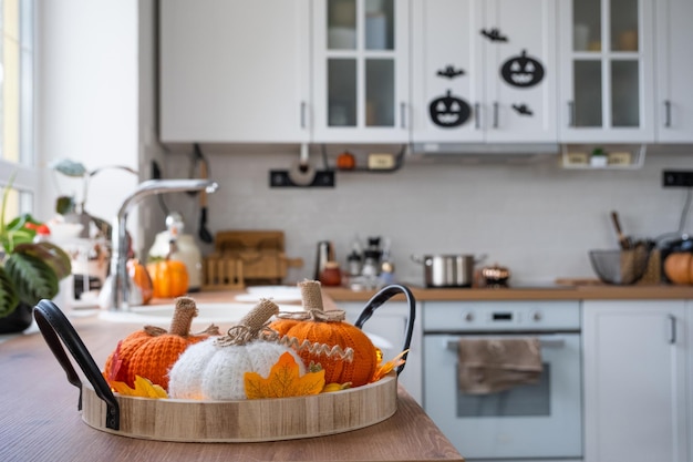 El interior de la cocina blanca Scandistyle está decorado con calabazas para Halloween Decoración del hogar con ambiente otoñal para las vacaciones