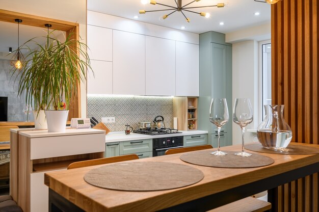 Interior de cocina blanco clásico moderno con zona de comedor