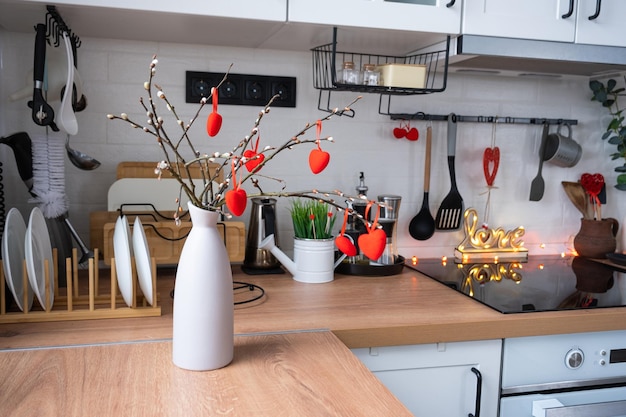 El interior de la cocina de la casa está decorado con corazones rojos para el Día de San Valentín Decoración en los utensilios de cocina de mesa ambiente festivo en un nido familiar