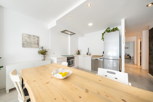 Interior de cocina y comedor contemporáneos con muebles blancos diseñados en estilo minimalista en el apartamento