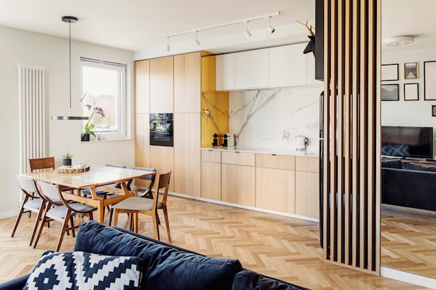 Interior de cocina y comedor escandinavo con estilo con mesa familiar, sillas y accesorios