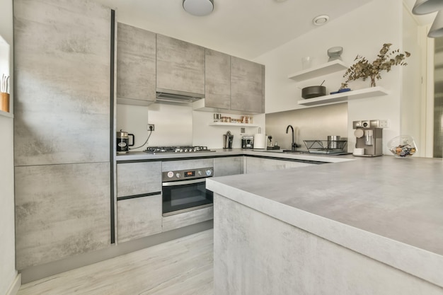 El interior de la cocina en un diseño gris con equipamiento moderno en una casa acogedora