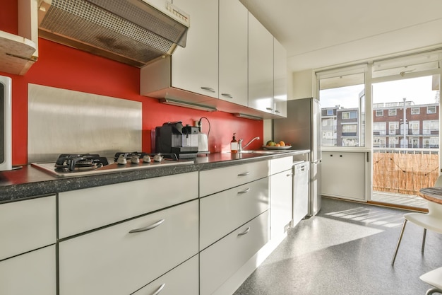 El interior de la cocina con equipamiento moderno y acceso al balcón en una casa moderna.