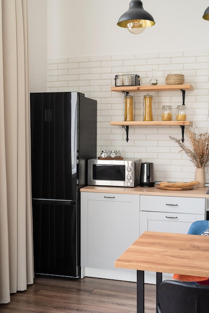 Interior de cocina de estilo rústico con utensilios de cocina antiguos y paredes de madera Muebles blancos y decoración de madera en una cabaña luminosa interior