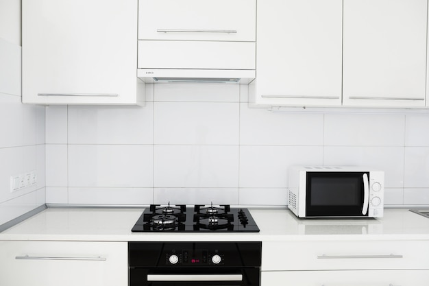 Cocina moderna en blanco y negro. Hermoso interior nuevo. Horno microondas,  placa eléctrica y horno eléctrico integrados, tecnología Fotografía de  stock - Alamy