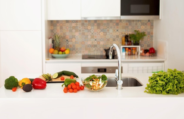 Interior de cocina moderna con verduras frescas en la encimera en el interior