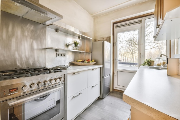 Pequeño Interior De Cocina Bien Organizado Con Fregadero Bajo La Ventana Y  Muebles Ligeros Con Estufa Y Nevera En Un Apartamento Urbano Fotos,  retratos, imágenes y fotografía de archivo libres de derecho.