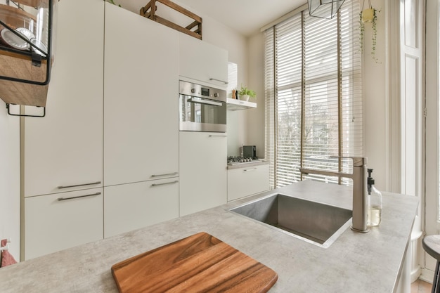 El interior de la cocina en tonos blancos en el suelo de parqué de una casa moderna