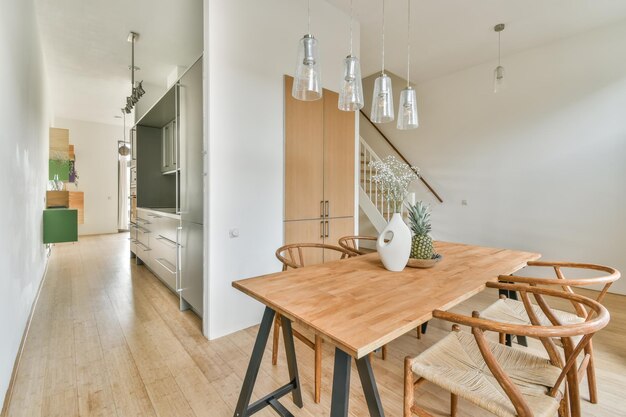 Interior del comedor al lado de las escaleras a la cima y un jarrón de flores sobre la mesa