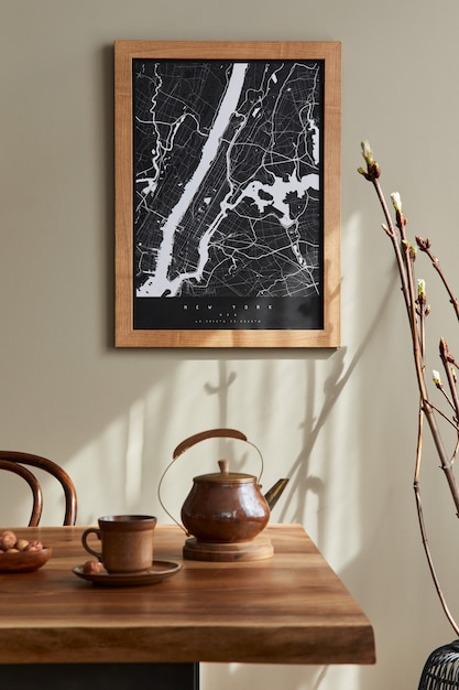 Interior de comedor elegante con mapa de póster simulado, mesa de madera de nogal, sillas de diseño, taza de café, decoración, vajilla y elegantes accesorios personales en la decoración del hogar. Modelo.