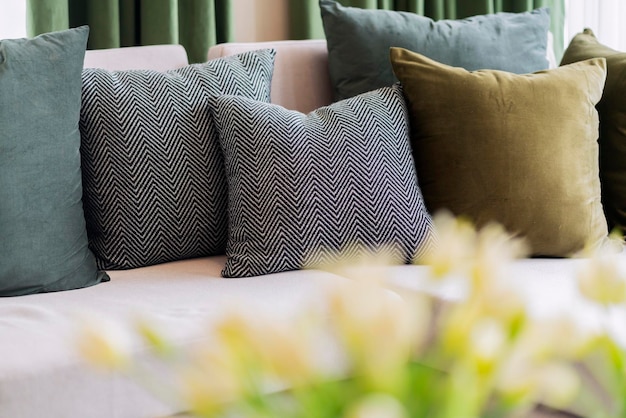 Interior contemporâneo da sala de estar com parte do sofá e organizar o conjunto de almofada de decoração em dia ensolarado e conceito de fundo de design de detalhes de interiores de cortina branca