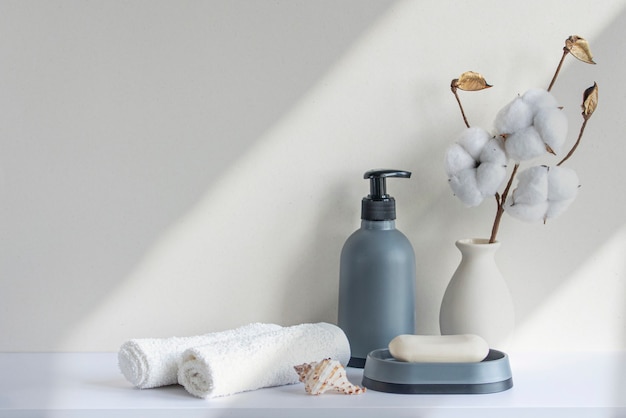 Interior del cuarto de baño en estante blanco de tono beige pastel en el baño con botella de champú y jabón