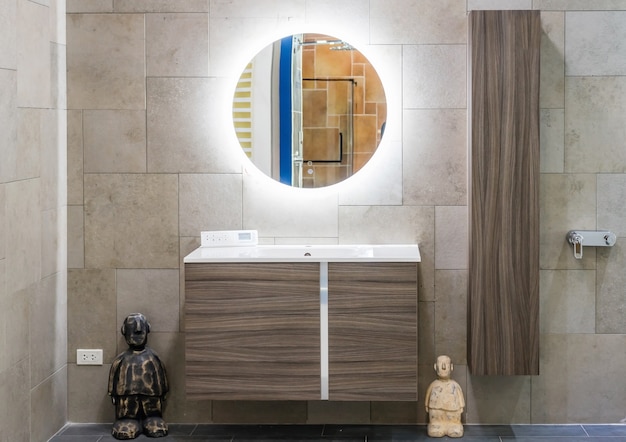 Interior del cuarto de baño con lavabo, grifo y espejo.