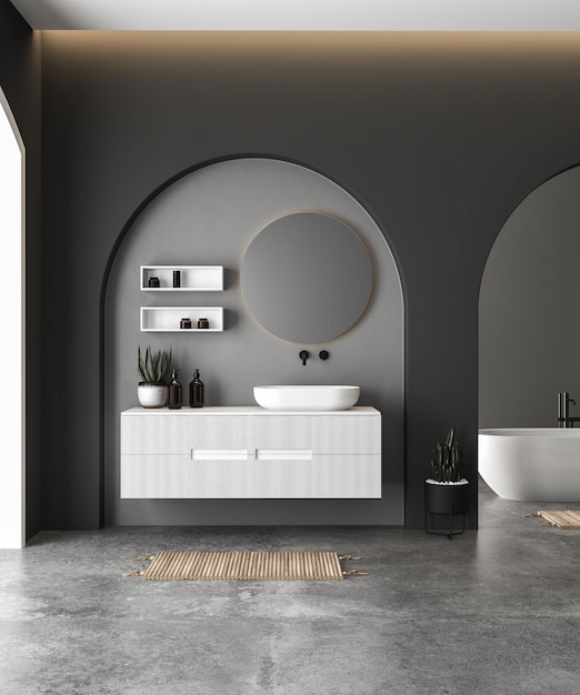 Interior de cuarto de baño moderno con paredes negras y de hormigón, suelo de hormigón y lavabo blanco.