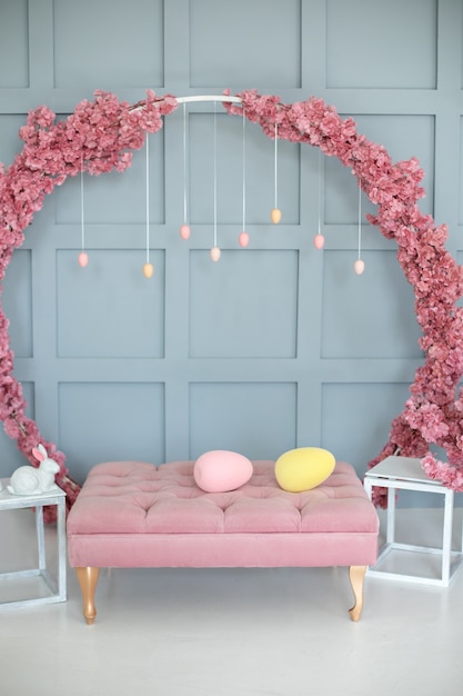 interior da casa com sofá rosa coroa de sakura grande na parede Decoração de Páscoa da sala de estar