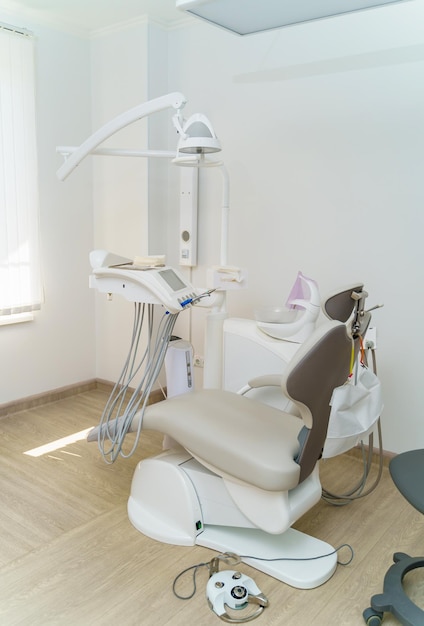 Interior da clínica odontológica com cadeira odontológica Ferramentas odontológicas e equipamentos de iluminação dental Conceito de cuidados orais