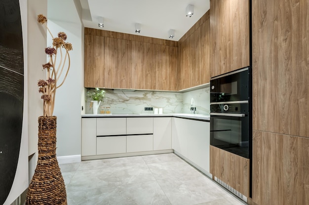 Interior da cozinha de luxo moderna em estúdios em estilo minimalista com luz e cor de madeira