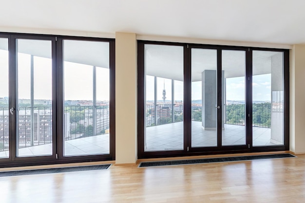 Interior de apartamento loft vazio branco moderno com piso em parquet e janelas panorâmicas com vista para a cidade metrópole