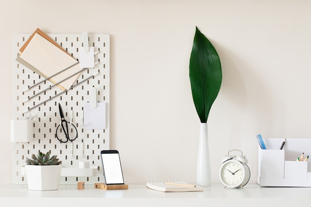 Interior de mesa elegante com fundo de mesa branca com plantas e folhas. interior moderno de home office