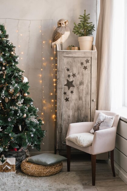 Interior de Natal escandinavo decorado com uma árvore de Natal no guarda-roupa do quarto infantil com poltrona de brinquedos infantis