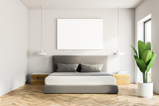 Interior de quarto branco com piso de madeira, uma cama principal e um cartaz horizontal pendurado acima dele.