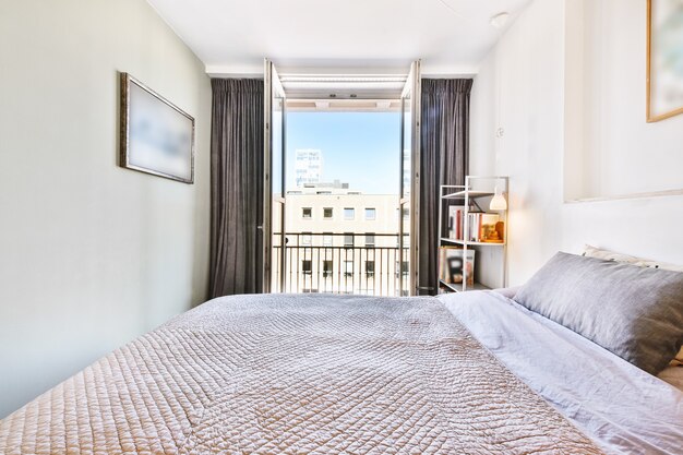 Interior de quarto espaçoso e claro com varanda em apartamento contemporâneo durante o dia ensolarado