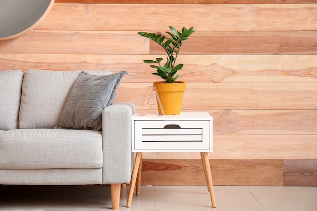 Interior de um quarto moderno com sofá confortável e mesa perto da parede de madeira