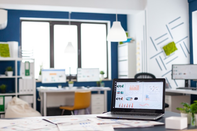 Interior de uma aconchegante sala de empresa leve com laptop, pronto para brainstorming, cadeiras elegantes e modernas, tudo pronto para os funcionários. Esvazie o escritório espaçoso de espaço de trabalho criativo.