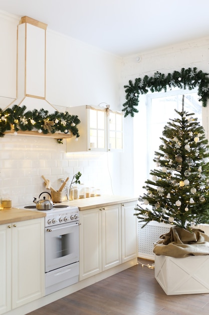 Interior de uma cozinha iluminada de Natal decorada com uma árvore de Natal e guirlandas