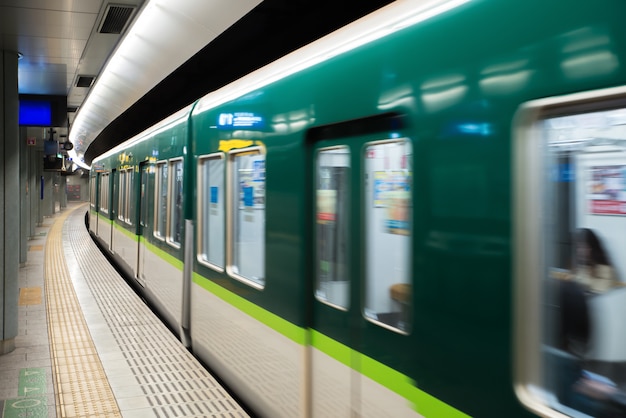 Interior de uma estação de metro de Tokyo e plataforma com os assinantes do metro no Tóquio, Japão.