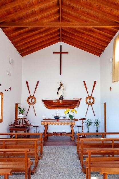 Foto interior de uma igreja católica com cruz e altar de madeira