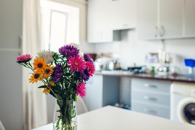 Interior de diseño de cocina moderna de cocina blanca y plateada decorada con ramo de flores acogedor ap