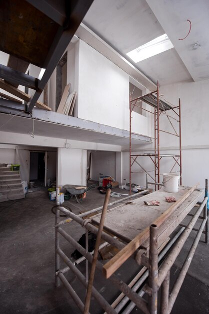 Foto interior do canteiro de obras com andaimes em um grande apartamento duplex inacabado e moderno