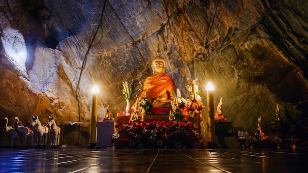 Interior do templo dourado de Tham pha jom na caverna em Chiang Rai, Tailândia