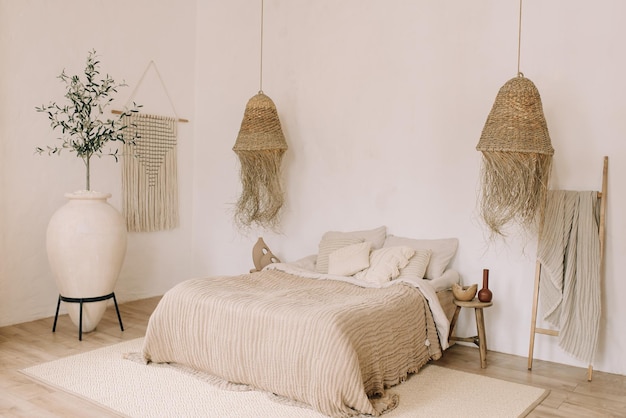 Interior de dormitorio de estilo boho Tonos cálidos claros cama grande lámparas decorativas de paja decorativas grandes