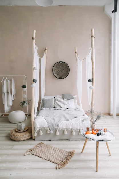 Interior de dormitorio moderno con cama con dosel de madera y manta de almohadas y una mesita de noche