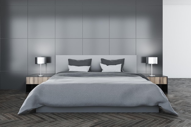 Interior de dormitorio moderno con paredes grises, un piso de hormigón, una cama principal y dos mesas de noche con lámparas.